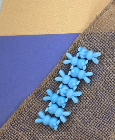 Eight ocean-colored bunny-shaped soy wax melts arranged horizontally, showcasing an invigorating chill of ocean air.