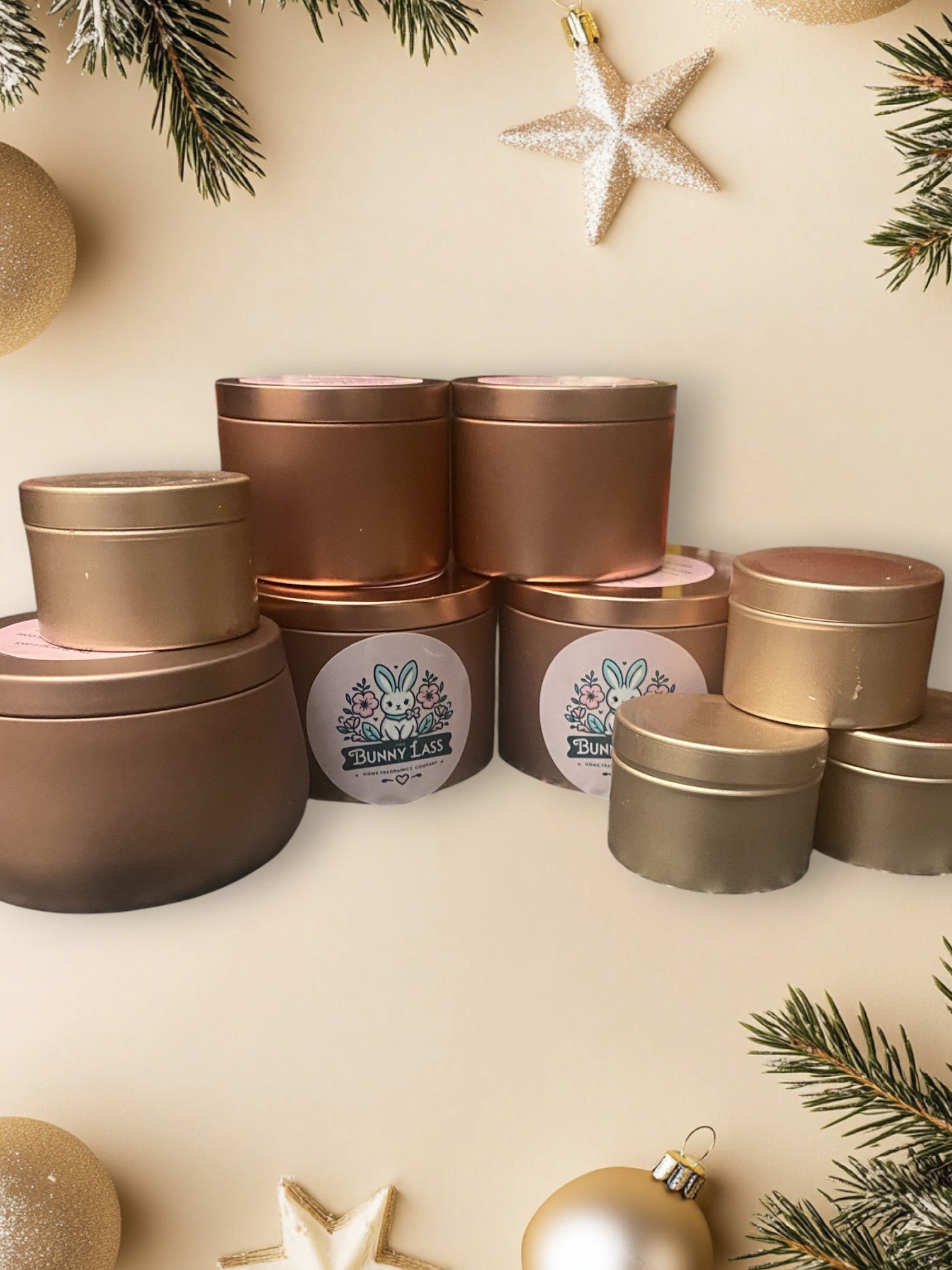 Three different sizes of a can of bunny-shaped scented soy wax melts and candles on a cream-colored surface surrounded with Christmas tree decors.